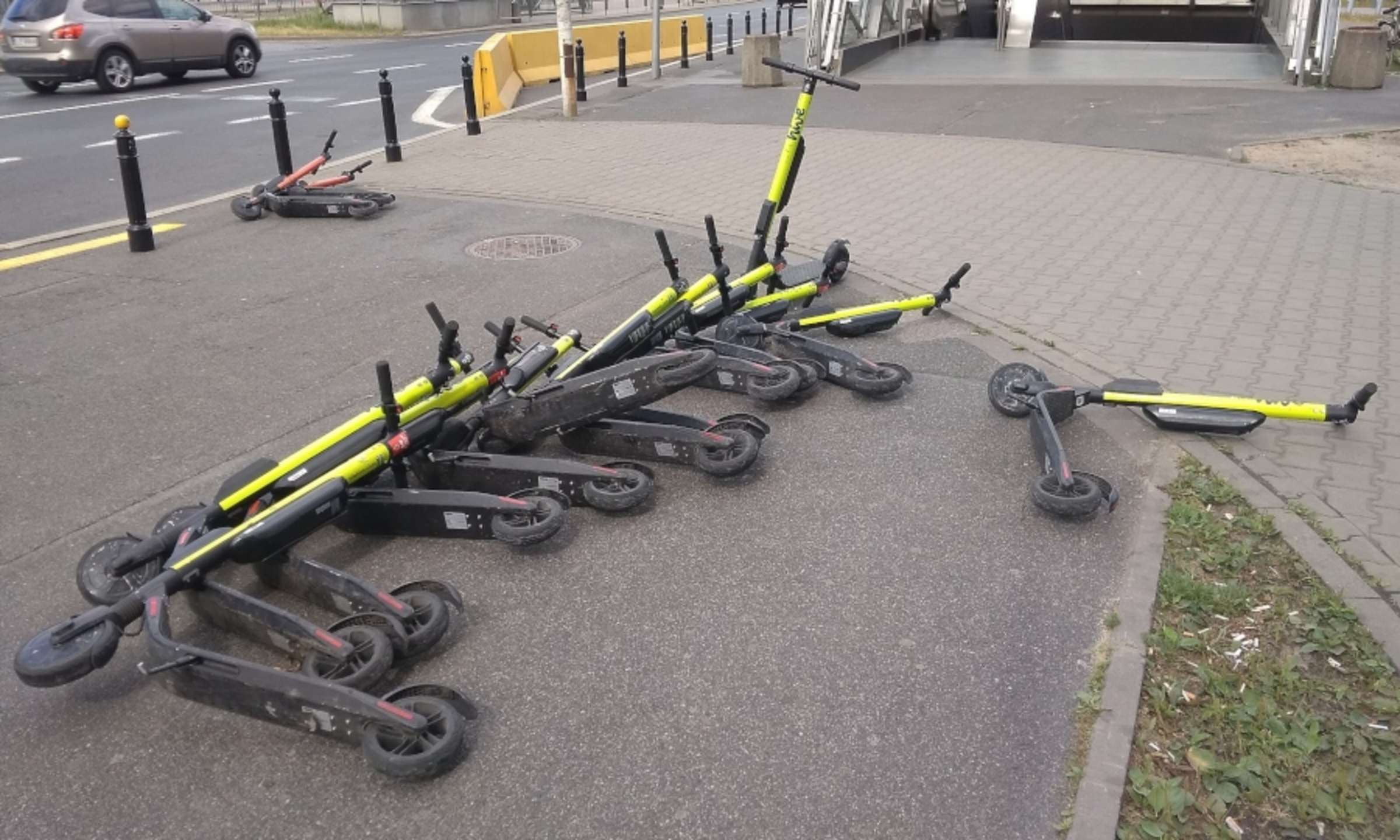 E-scooters littering a sidewalk.