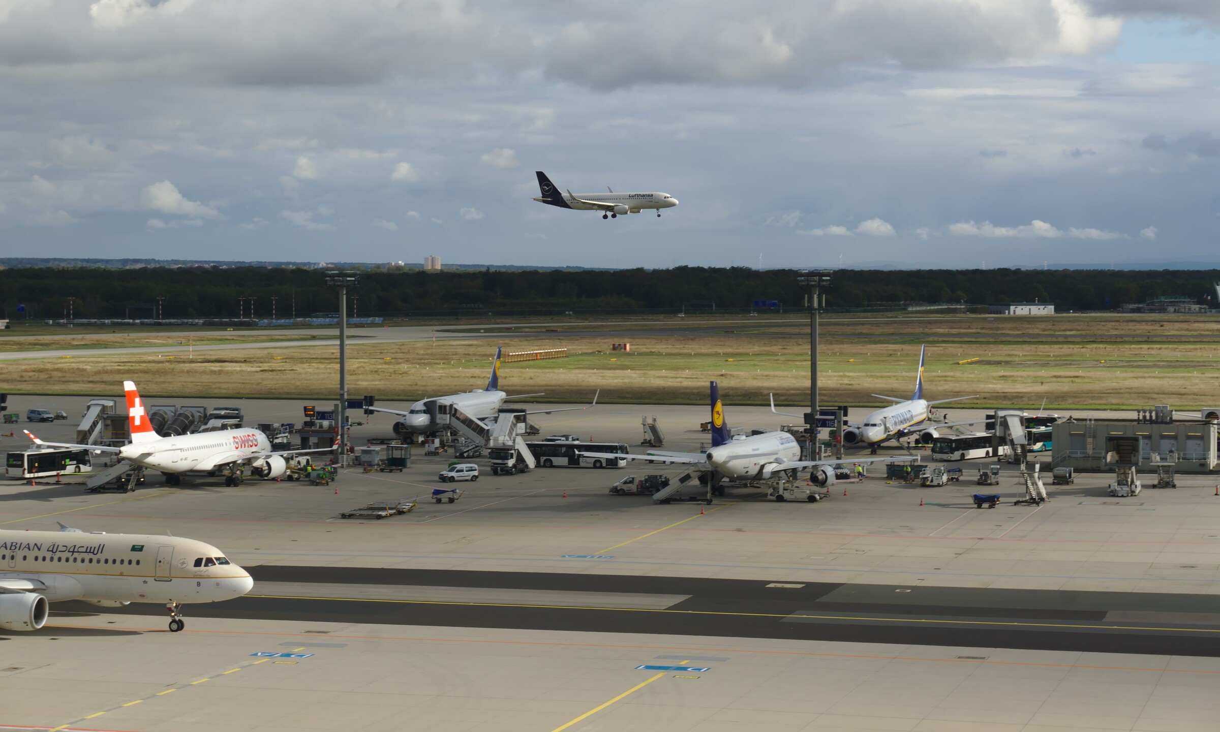 A plane landing behind some other planes being processed.