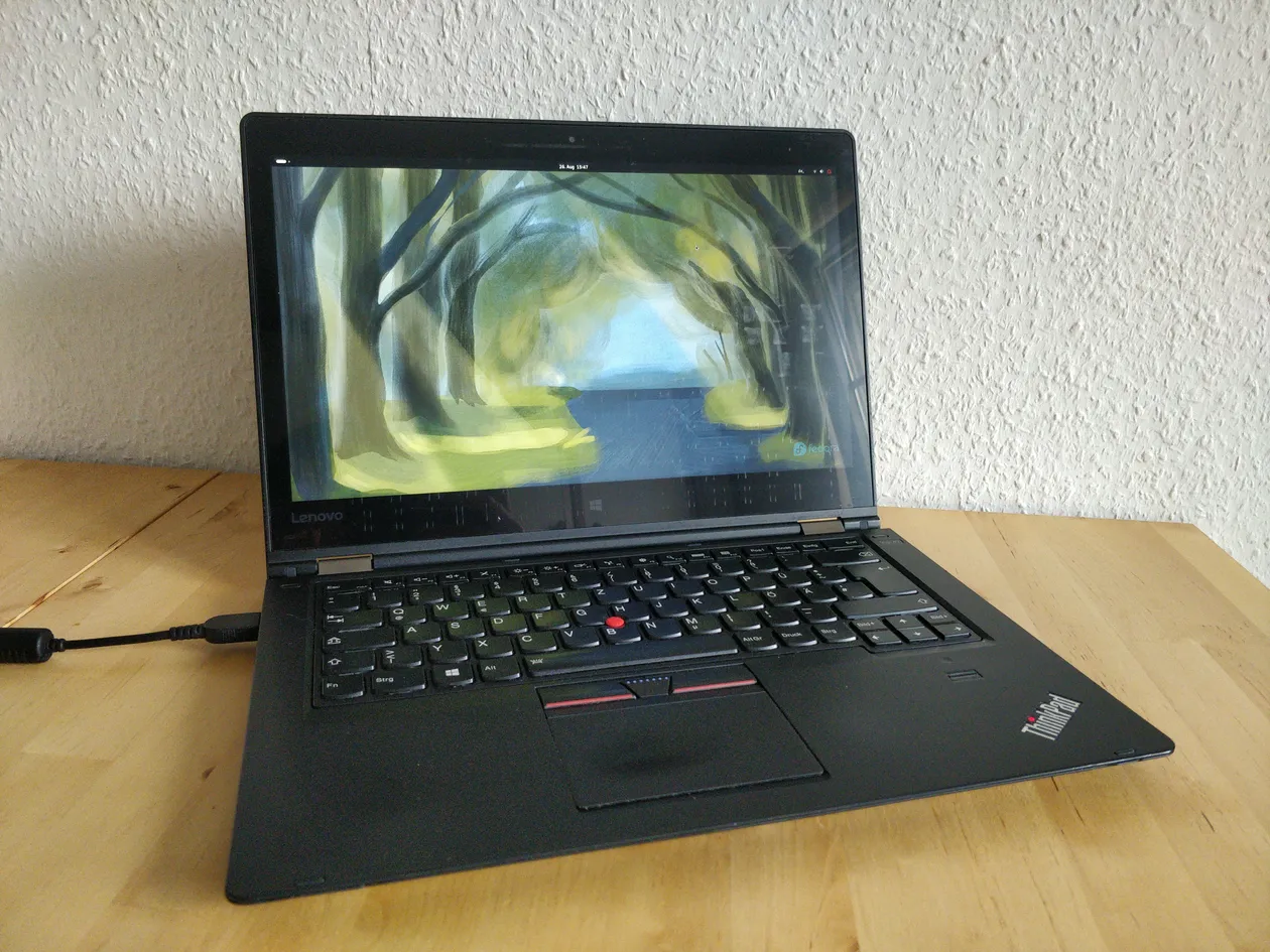 A black ThinkPad Yoga 460 with open lid. A Fedora desktop on the screen.